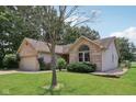 Beautiful brick and siding home featuring a well-maintained lawn and mature trees at 1311 Old Hickory Dr, Greenwood, IN 46142
