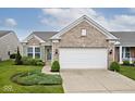 Inviting home exterior with a two-car garage, brick accents, and a neatly landscaped front yard at 15937 Marsala Dr, Fishers, IN 46037
