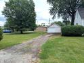Long driveway leading to a detached garage with ample green space on either side at 1637 Meridian St, Columbus, IN 47201