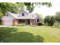 Charming two-story home with brick facade, arched windows, manicured lawn, and pond view at 1739 S County Road 450 E, Avon, IN 46123
