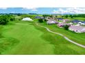 Scenic aerial view of a golf course community with homes, a pond, and lush green fairways at 217 Saint Andrews Ave, Edinburgh, IN 46124