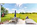 Relaxing outdoor patio with a table, chairs, grill and lovely views of the green golf course at 217 Saint Andrews Ave, Edinburgh, IN 46124