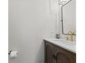 Elegant half-bathroom featuring a modern vanity with gold faucet and a sleek, black-framed mirror at 2580 Bluewood Way, Plainfield, IN 46168