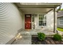 Inviting front porch features a red door and large windows, creating a warm and welcoming entrance to the home at 3818 Fetlock Dr, Indianapolis, IN 46227