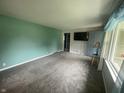 View of the living room showing ample space with blue accent wall and natural light from the windows at 4363 Roosevelt Dr, Columbus, IN 47201