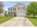 Traditional two-story home with a spacious driveway, attached garage, and a inviting front porch at 5631 N Peppereel Way, McCordsville, IN 46055