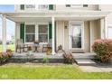 Cozy front porch with seating, flower pots, and a charming entrance to the home at 5631 N Peppereel Way, McCordsville, IN 46055
