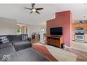 Open-concept living area with hardwood floors, neutral colors, a ceiling fan, and a view of the kitchen at 5967 Peregrine Blvd, Indianapolis, IN 46228