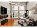 Spacious living room with high ceilings, hardwood flooring, and access to an outdoor patio at 611 N Park Ave # 104, Indianapolis, IN 46204