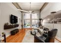 Bright living room featuring high ceilings, hardwood floors, and sliding glass doors to a patio at 611 N Park Ave # 104, Indianapolis, IN 46204