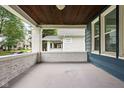 Covered front porch with brick detail, wood ceiling and a view of the surrounding neighborhood at 614 N Drexel Ave, Indianapolis, IN 46201