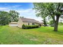 Home exterior with a detached garage and spacious, well-manicured lawn at 6308 Ratliff Rd, Indianapolis, IN 46113