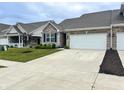 Well-maintained townhome featuring brickwork, a two-car garage, and a paved driveway at 6350 Stallion Way, Indianapolis, IN 46260