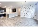 Open-concept living space showcasing modern light fixtures, beautiful floors, and stylish accent wall at 6350 Stallion Way, Indianapolis, IN 46260