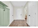 Bright hallway featuring stylish wood-look flooring, white doors, and modern wall accents at 6853 Kellum Dr, Indianapolis, IN 46221
