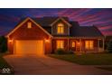 Beautiful two-story brick home with a front porch and manicured lawn at dusk at 7082 Hunters Ridge Dr, Plainfield, IN 46168