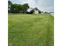 Spacious and well-maintained green lawn with a charming white fence bordering the property at 7195 W 700 N, Fairland, IN 46126