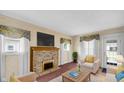 Cozy living room with brick fireplace, TV, neutral furniture and natural light at 753 Walnut St, Franklin, IN 46131