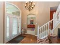 Welcoming foyer with hardwood floors, chandelier, staircase, and views into the living spaces at 7818 Fawnwood Dr, Indianapolis, IN 46278