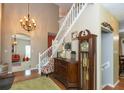 Grand foyer featuring a staircase, chandelier, wood floors, and antique decor accents at 7818 Fawnwood Dr, Indianapolis, IN 46278