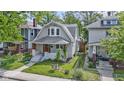Charming two-story home with a well-manicured lawn and a real estate sign at 909 N Parker Ave, Indianapolis, IN 46201
