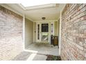 Covered front porch featuring brick accents and a white front door with a storm door and sidelights at 11418 Geist Valley Dr, Indianapolis, IN 46236
