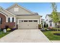 A well-lit two-car garage with a spacious driveway and neat landscaping at 11429 Lottie Cir, Noblesville, IN 46060