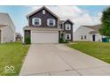 Two-car garage featuring a long driveway and adjacent landscaping at 1255 Crabapple Rd, Franklin, IN 46131