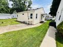 Home exterior with maintained grass, walkway, and outdoor utility area with table at 128 E 36Th St, Anderson, IN 46013