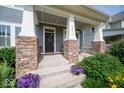 Close-up of the covered front porch with stone columns and a welcoming entrance at 12976 Walbeck Dr, Fishers, IN 46037