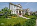 Inviting front yard featuring a lush green lawn, colorful flower beds, and a charming two-story home at 12976 Walbeck Dr, Fishers, IN 46037