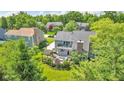 Home backyard showcasing patio area, fire pit, professional landscaping, and mature trees at 13304 Landwood Dr, Fishers, IN 46037
