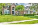 Beautiful brick home featuring a well-manicured lawn, lush landscaping, and inviting facade at 13304 Landwood Dr, Fishers, IN 46037