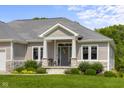Home's entry way features a well-manicured lawn with a welcoming front porch and stylish decor at 1497 Maple Ridge Ct, Columbus, IN 47201