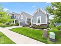 A lovely gray home sits among other colorful homes, with a sidewalk, green lawn, and beautiful landscaping at 1505 Avondale Dr, Westfield, IN 46074