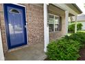 Close up of a home's entry way with brick facade, a blue door, and manicured shrubbery at 15524 Follow Dr, Noblesville, IN 46060