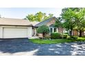 Attractive brick home featuring attached garage and lush landscaping around the facade at 1663 Cloister Dr, Indianapolis, IN 46260