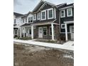 View of new townhomes featuring stone accents, covered porches, and horizontal siding at 19541 Grassy Branch Rd, Westfield, IN 46074
