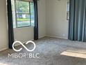 Bright living room featuring neutral walls, carpet, large windows with stylish curtains, and ample natural light at 2028 Gilmore St, Columbus, IN 47201