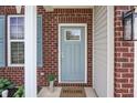 Front door detail with blue paint, glass pane, and a welcome mat, complemented by brick and siding at 2101 Shadow Fox Dr, Columbus, IN 47201