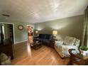 Bright living room features wood floors, large windows, and stylish furnishings, creating a cozy and inviting atmosphere at 386 Shadow Hill Dr, Greenwood, IN 46142