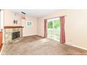 The living room features a fireplace, sliding glass doors and plush neutral carpeting at 392 Aspen Dr, Carmel, IN 46032