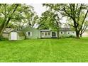 The house has a small, green storage shed and a sliding glass door at 415 N 3Rd St, Elwood, IN 46036