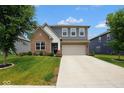 Inviting two-story home showcasing a brick facade, gray siding, neat landscaping, and a spacious driveway at 4832 W Safford Dr, New Palestine, IN 46163