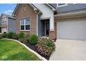 Close-up of a home's exterior, highlighting brick accents, siding, and neatly trimmed landscaping at 4832 W Safford Dr, New Palestine, IN 46163