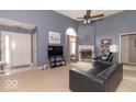 Inviting living room with a cozy fireplace and ample natural light flowing through a large window at 5104 W Prairiewood Dr, Muncie, IN 47304