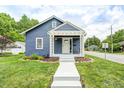 Charming blue house with covered porch, green lawn, and tree backdrop at 5203 Carrollton Ave, Indianapolis, IN 46220
