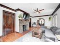 Comfortable living room with hardwood floors, a brick fireplace, and a gray sectional couch at 5203 Carrollton Ave, Indianapolis, IN 46220