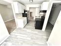 Galley style kitchen with white cabinets, stainless steel refrigerator and black appliances at 5826 Buck Rill Dr, Indianapolis, IN 46237
