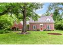 Charming brick home featuring a well-manicured lawn and classic architectural details at 6220 E 56Th St, Indianapolis, IN 46226